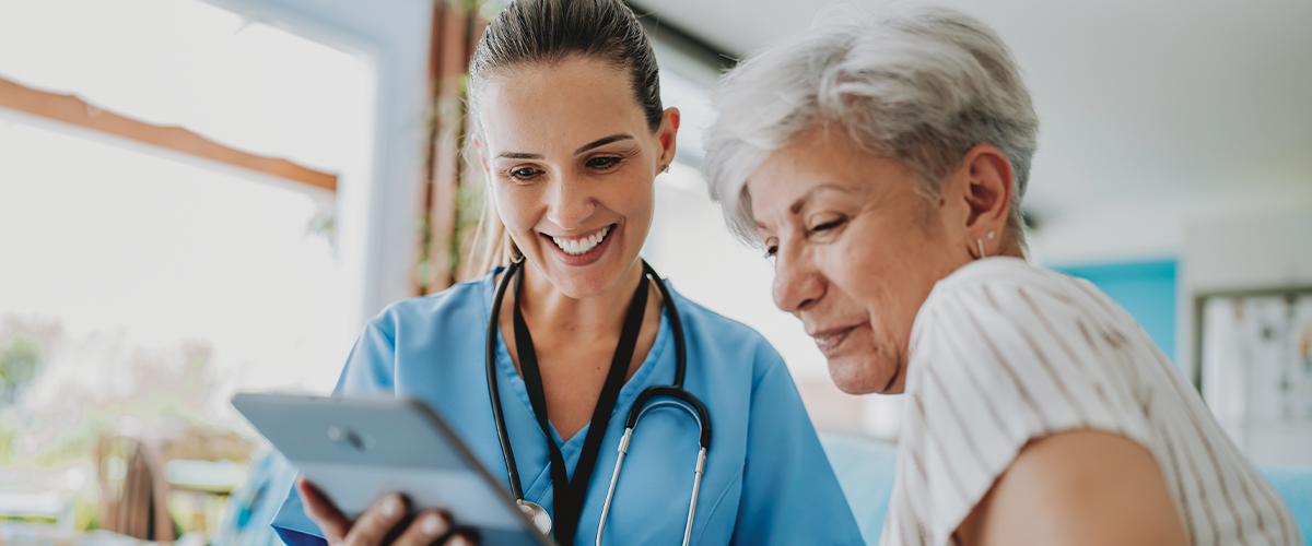 Woman and healthcare professional looking at a tablet.